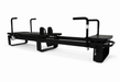 Full length view of the Elina Corextreme Pilates reformer in black with padded platforms and adjustable handles