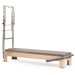 Elina Pilates Elite Advanced Reformer with Tower in rock maple featuring the infinite sliding foot bar, padded box, and jump board for home and commercial studios.