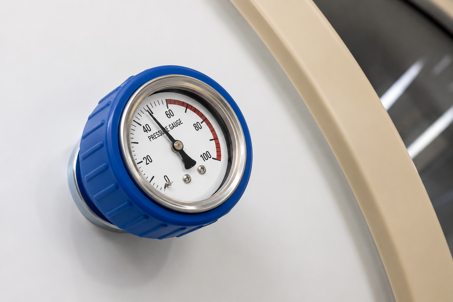 Close-up of a pressure gauge with blue casing on a white surface.
