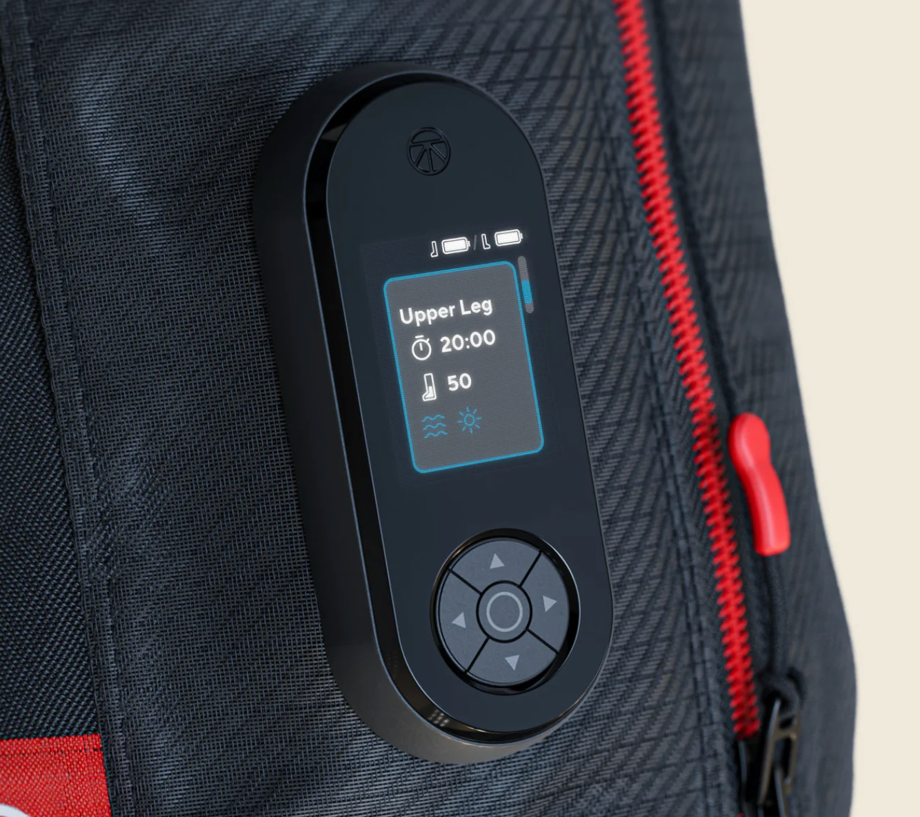 A close-up of a black handheld electronic device with a small color display and directional pad, attached to or placed on a dark textured bag with red zipper accents.